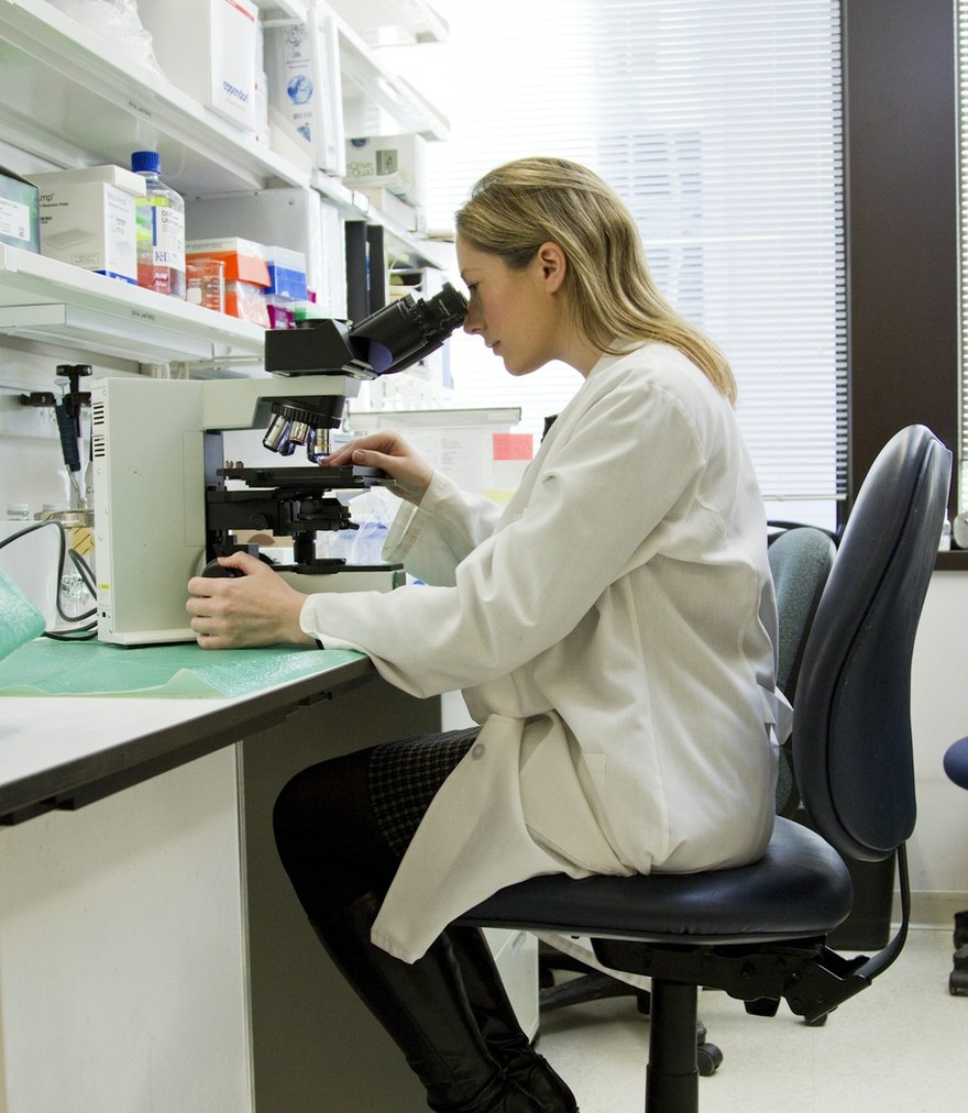Lab technician examining a diagnostic sample under a microscope